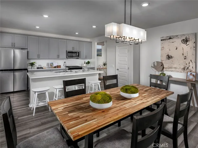 a kitchen with a table chairs and refrigerator