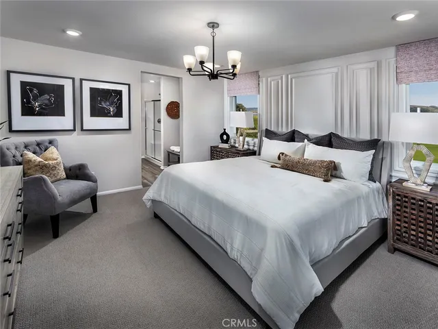 a bedroom with bed and a chandelier