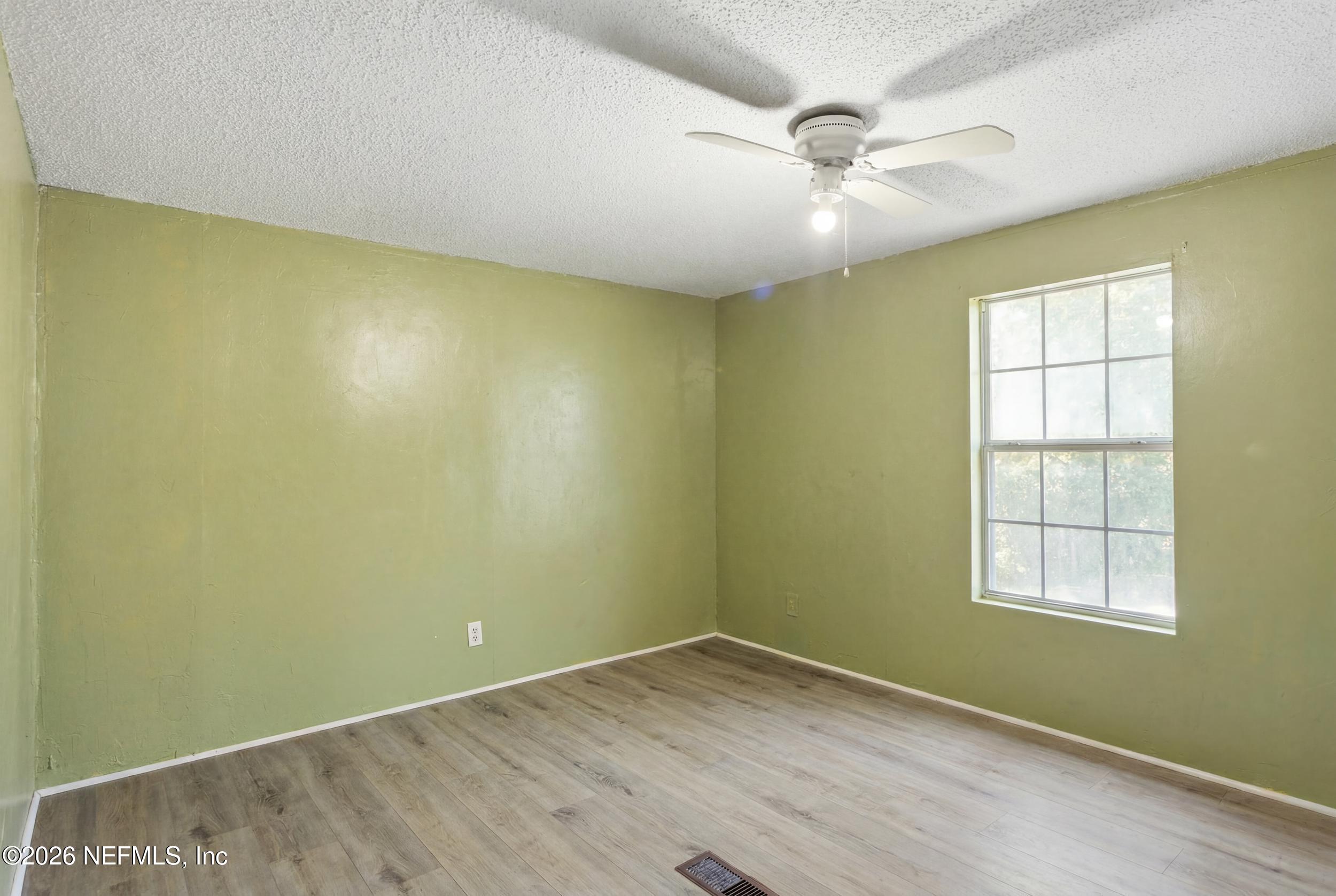 5667 Long Branch Cemetery Road Jacksonville, FL 32234 - Photo 16 of 24 an empty room with a ceiling fan and window