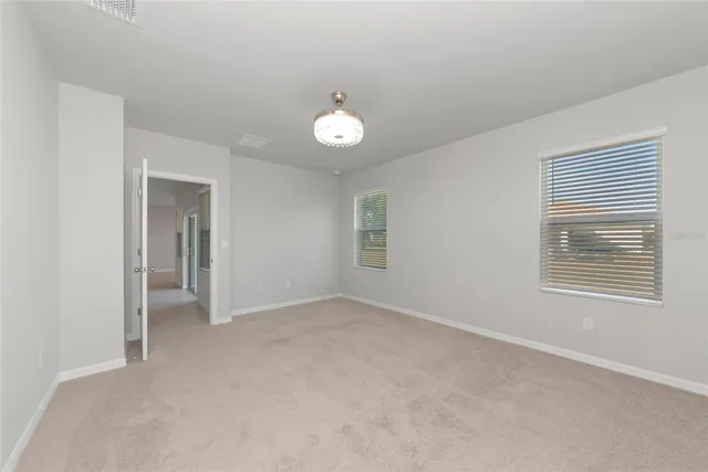 an empty room with a fan and a window