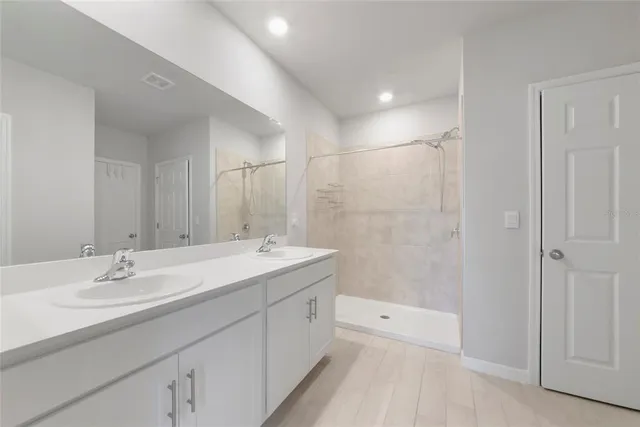 a spacious bathroom with a bathtub shower sink vanity and mirror
