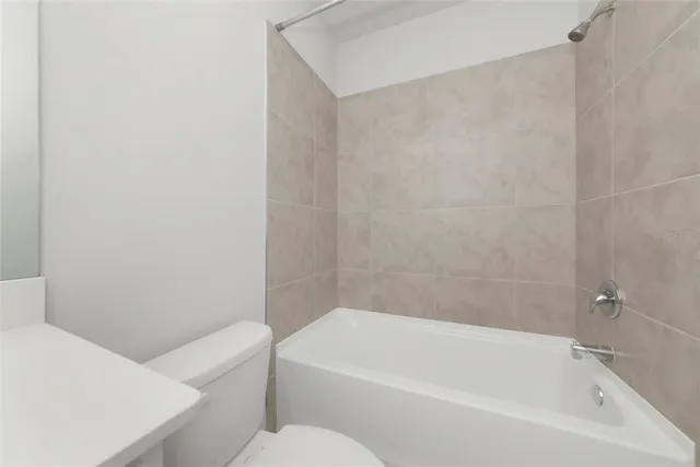 a bathroom with a toilet a sink a mirror and bathtub