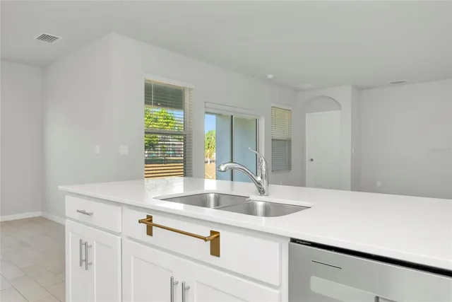 a kitchen with stainless steel appliances granite countertop a sink and a white cabinets