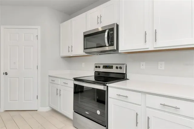 a kitchen with white cabinets and stainless steel appliances