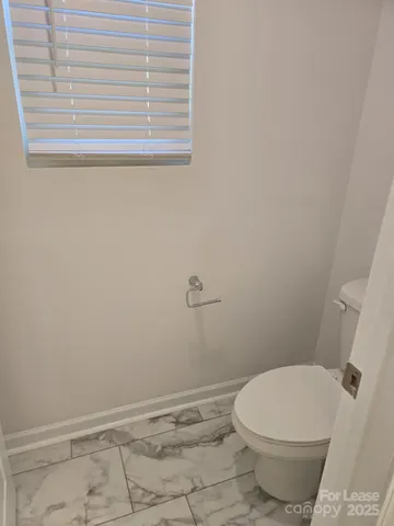 a white toilet sitting next to a window