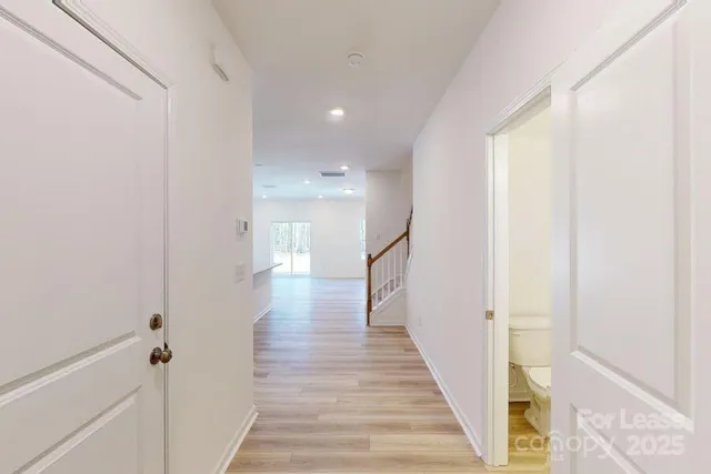a view of a hallway with wooden floor and staircase