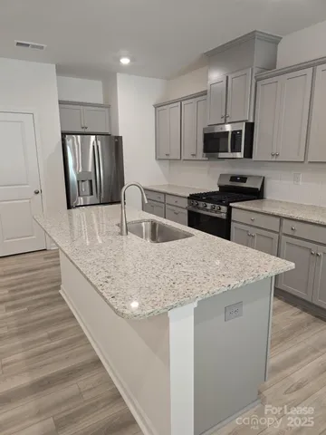 a kitchen with stainless steel appliances granite countertop a sink stove microwave and cabinets