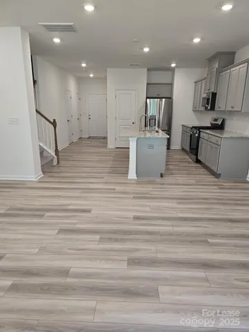 a open kitchen with kitchen island a sink stainless steel appliances and cabinets