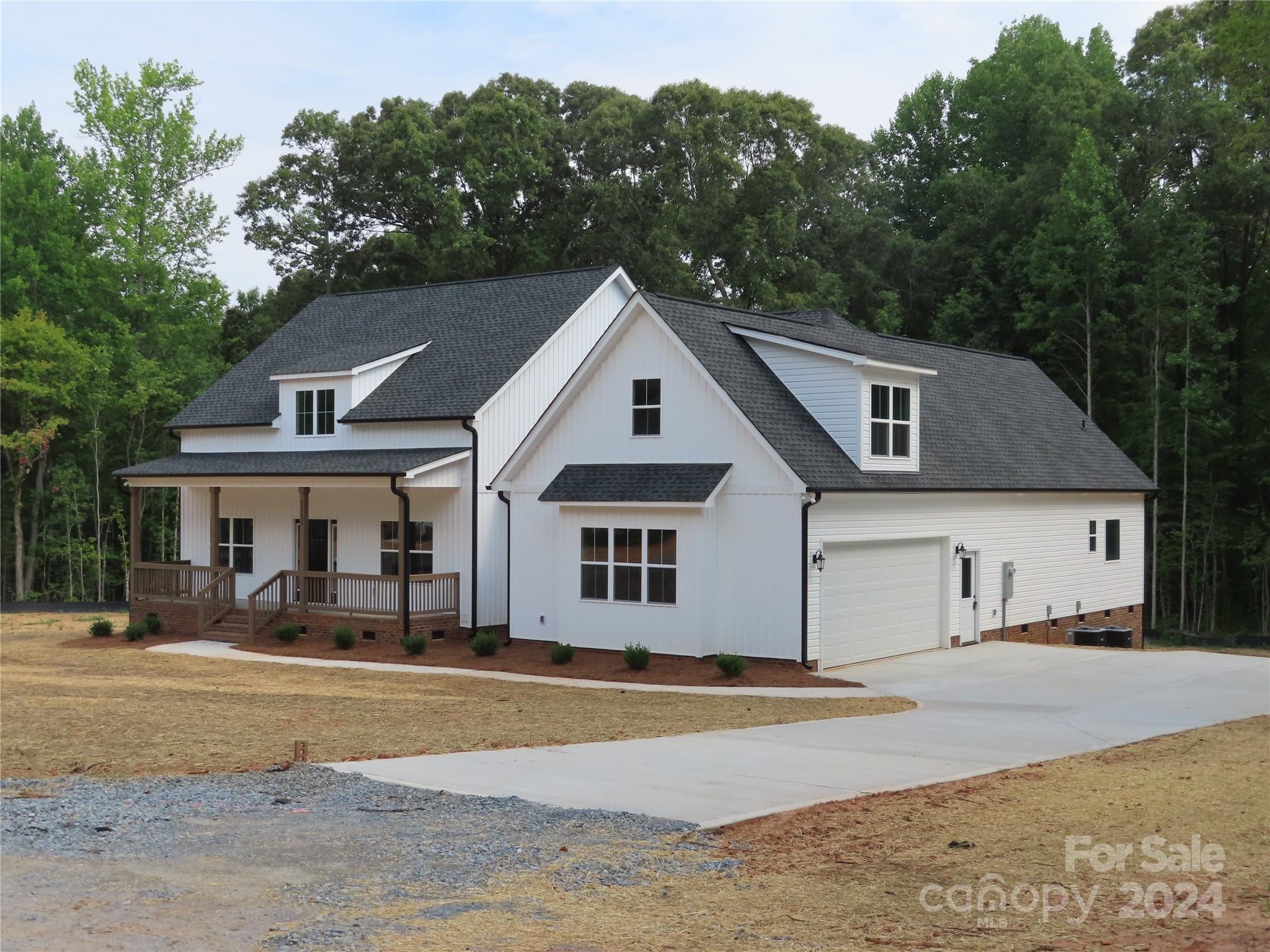 a front view of a house with a yard and trees