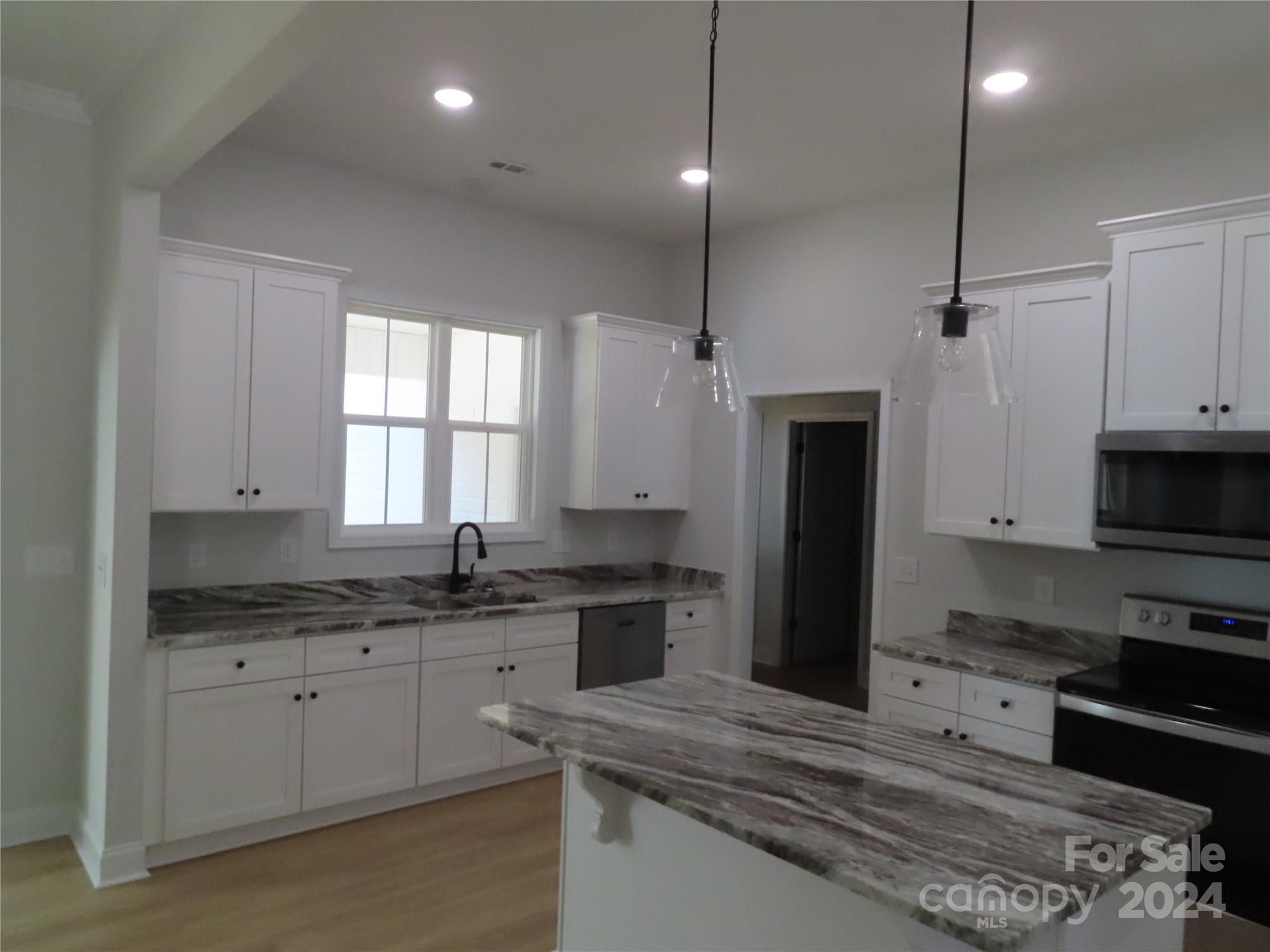 2225 Cedar Road, Unit 1 York, SC 29745 - Photo 12 of 31 a kitchen with kitchen island granite countertop a sink a counter space appliances and cabinets