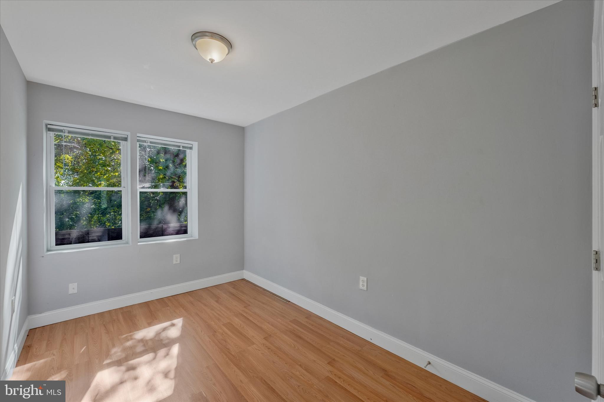 433 Atlantic Street Southeast Washington, DC 20032 - Photo 11 of 15 a view of an empty room with wooden floor and a window