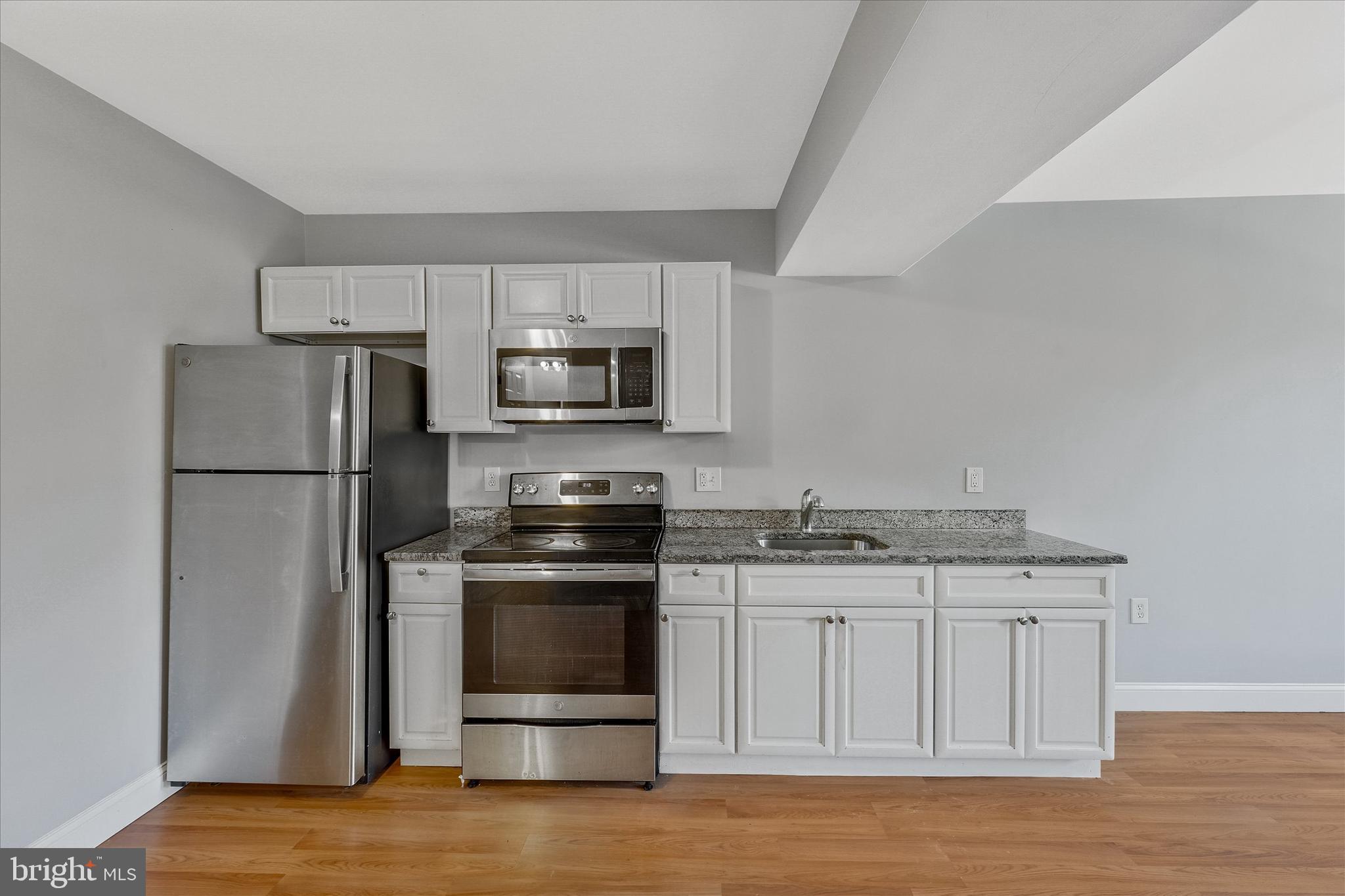 433 Atlantic Street Southeast Washington, DC 20032 - Photo 4 of 15 a kitchen with stainless steel appliances granite countertop a stove a refrigerator and a microwave