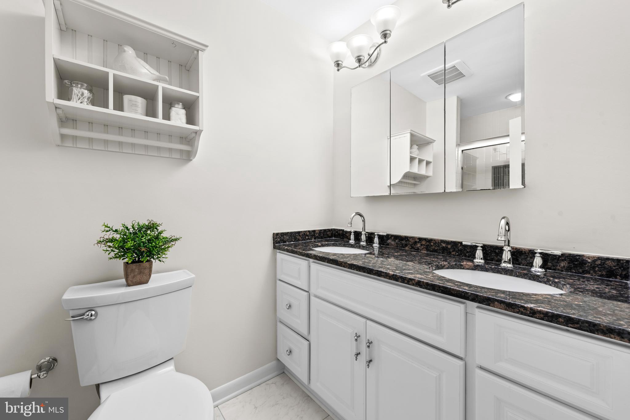 11711 Newbridge Court Reston, VA 20191 - Photo 23 of 37 a bathroom with a granite countertop sink mirror and vanity