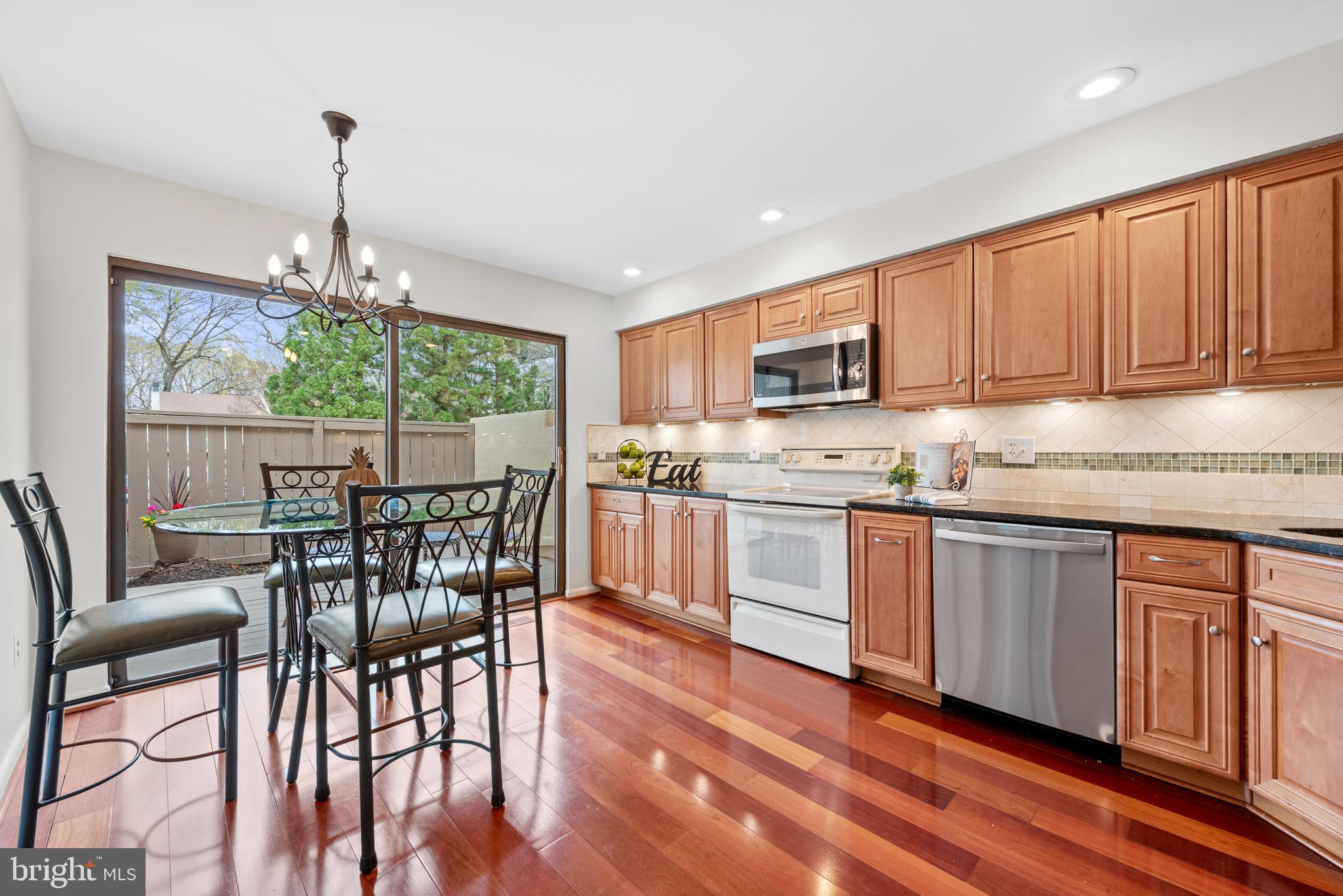 11711 Newbridge Court Reston, VA 20191 - Photo 10 of 37 a kitchen with granite countertop wooden floors furniture and a window