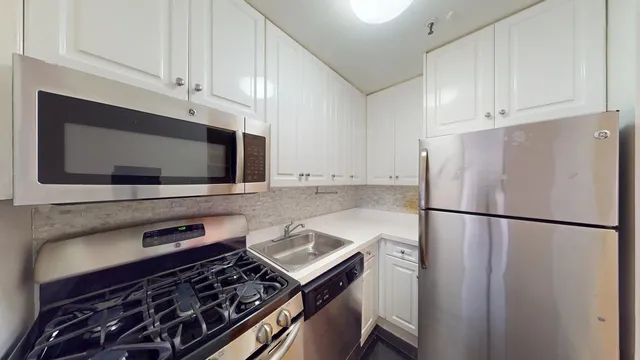 a kitchen with stainless steel appliances a refrigerator a stove a microwave and cabinets