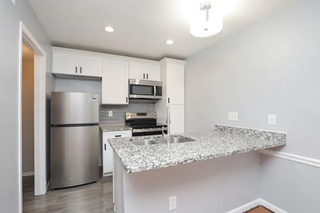 a kitchen with stainless steel appliances granite countertop a refrigerator sink and microwave