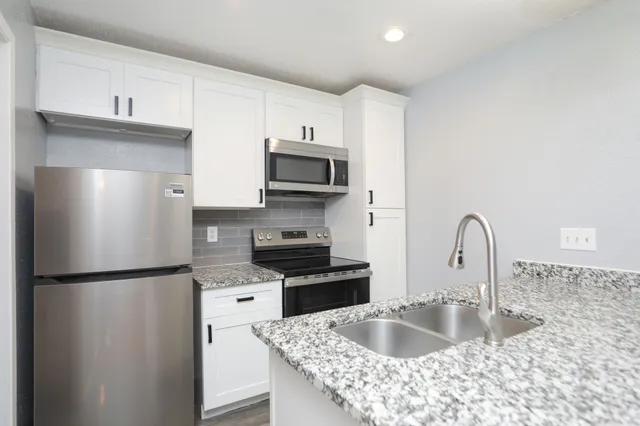 a bathroom with a granite countertop sink a bathtub and shower