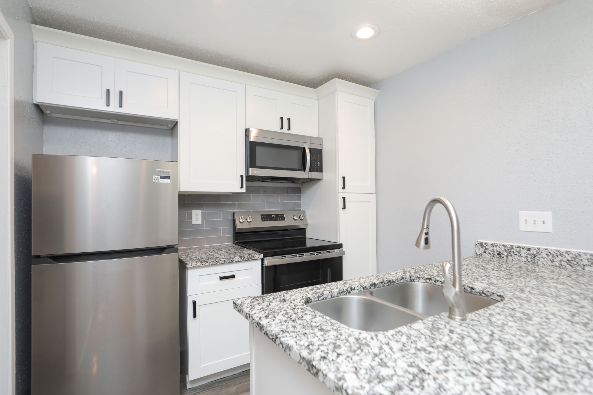 2100 Wilcrest Drive, Unit 127 Houston, TX 77077 - Photo 18 of 38 a kitchen with stainless steel appliances granite countertop a refrigerator sink and microwave
