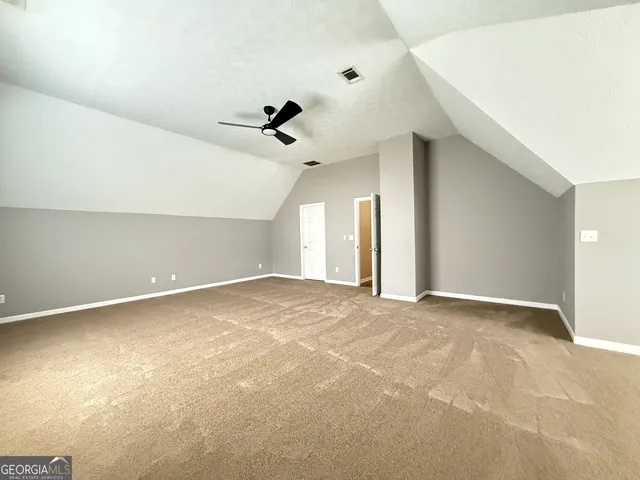 an empty room with a ceiling fan and window