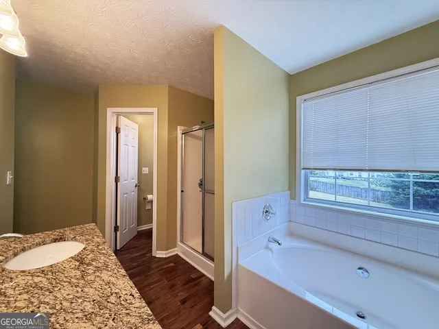 a spacious bathroom with a tub shower and a sink