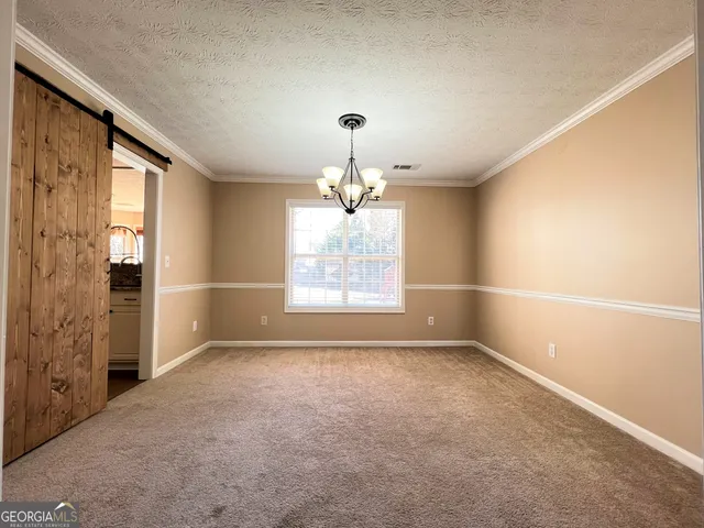 an empty room with windows and chandelier fan