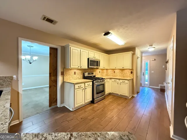 a kitchen with a refrigerator and a stove top oven