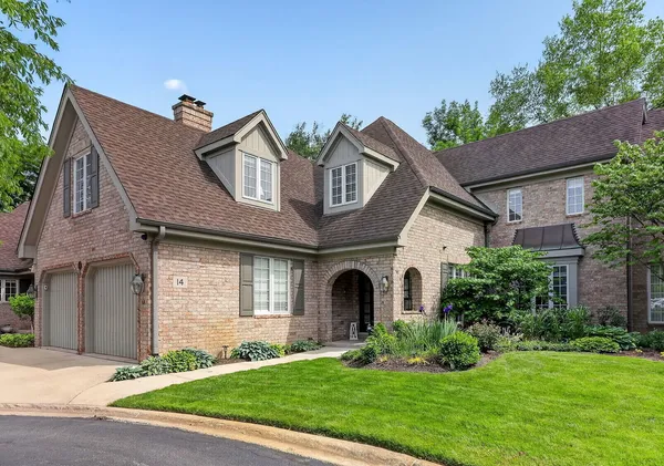 a front view of a house with a garden and plants