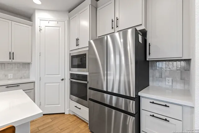 a kitchen with stainless steel appliances a refrigerator and cabinets