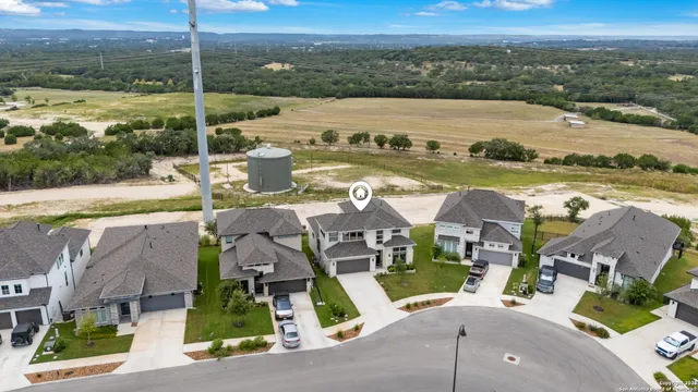 an aerial view of residential houses with outdoor space and ocean view