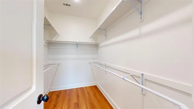 a view of walk in closet with empty racks