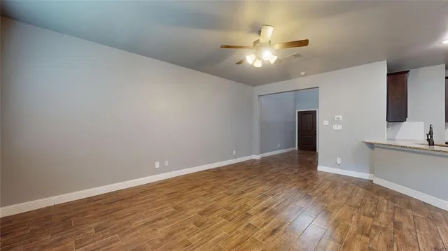 a view of an empty room with window and wooden floor