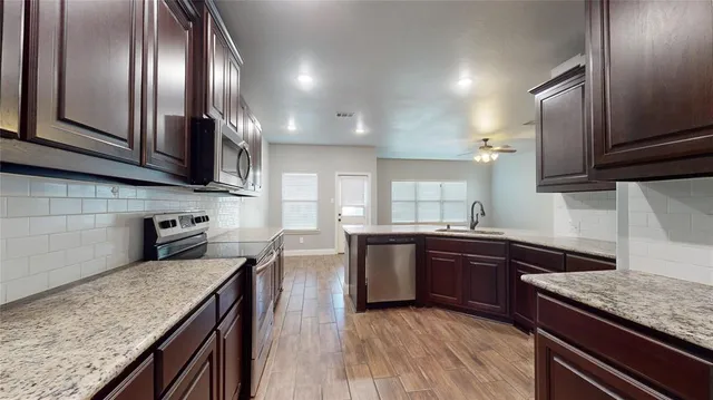a kitchen with stainless steel appliances granite countertop a sink stove and refrigerator