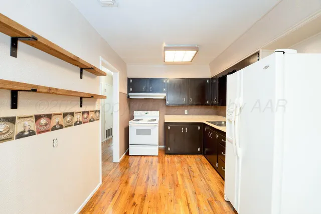 a kitchen with stainless steel appliances a refrigerator and a stove top oven