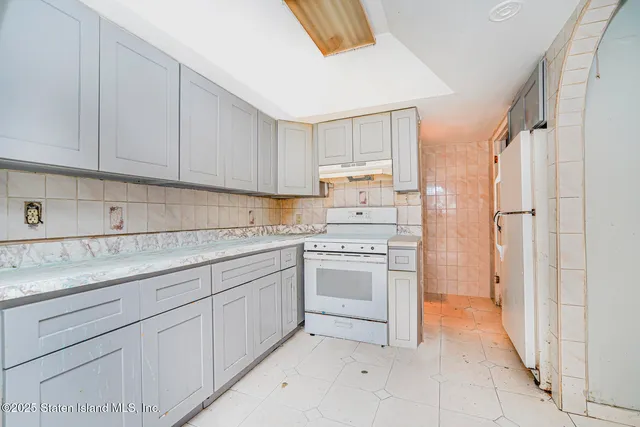 a kitchen with granite countertop white cabinets and stainless steel appliances
