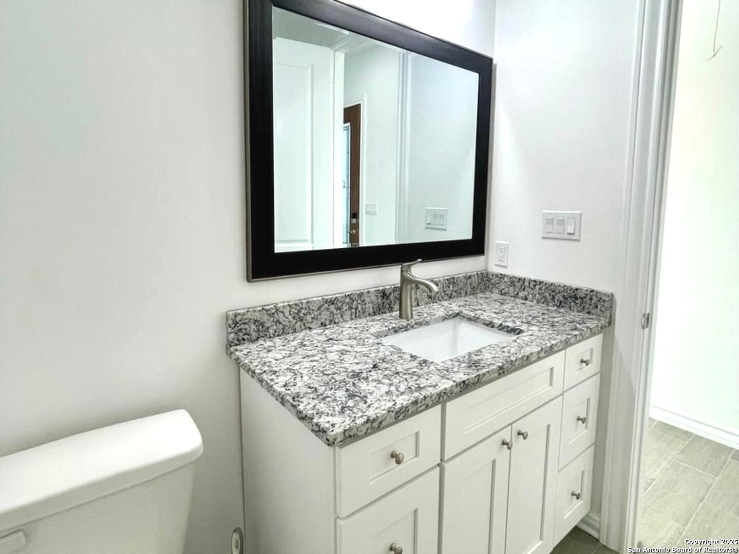 97 Berwick Road Victoria, TX 77904 - Photo 20 of 35 a bathroom with a granite countertop sink and a toilet
