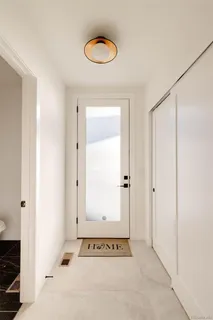 a view of a hallway with couches and wooden floor