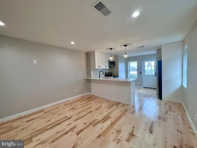 a view of kitchen and hall with wooden floor