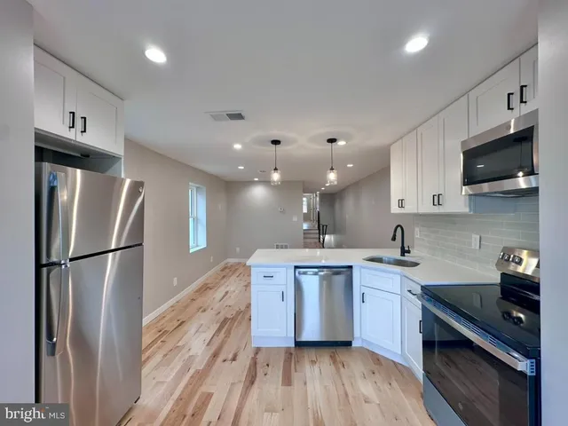 a kitchen with a sink stainless steel appliances and cabinets