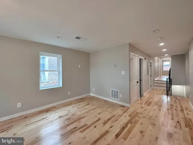 a view of empty room with wooden floor