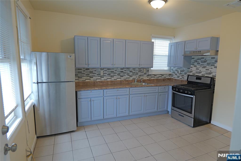 84 Scheerer Avenue Newark, NJ 07112 - Photo 4 of 9 a kitchen with stainless steel appliances granite countertop a refrigerator sink and stove