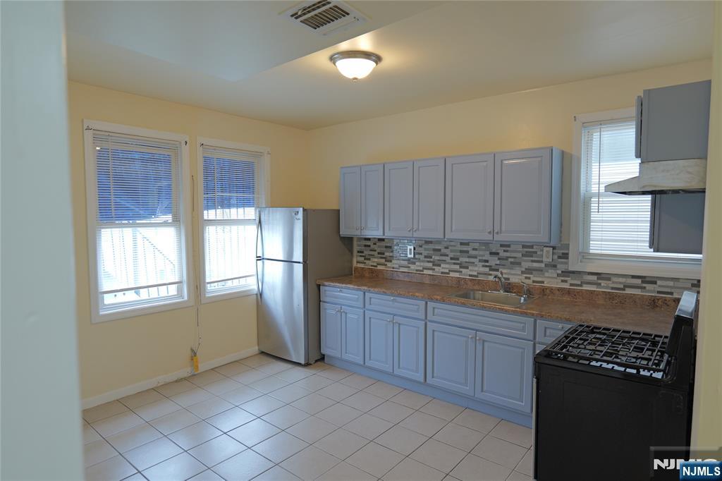 84 Scheerer Avenue Newark, NJ 07112 - Photo 5 of 9 a kitchen with granite countertop a refrigerator and a sink