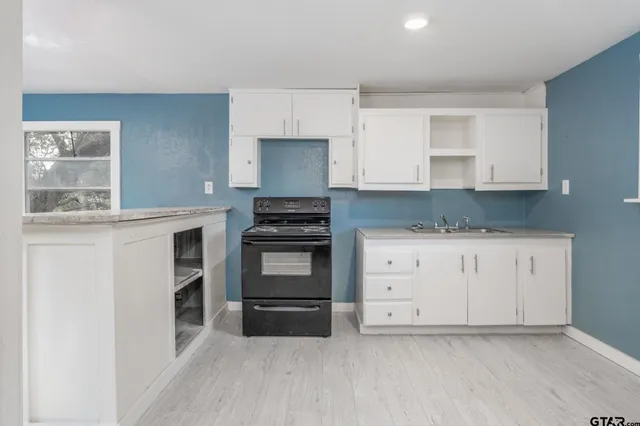 a kitchen with granite countertop white cabinets and stainless steel appliances