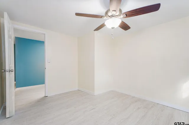 an empty room with fan and entrance