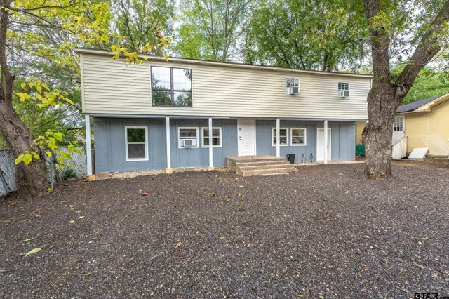 a front view of house with yard and trees around