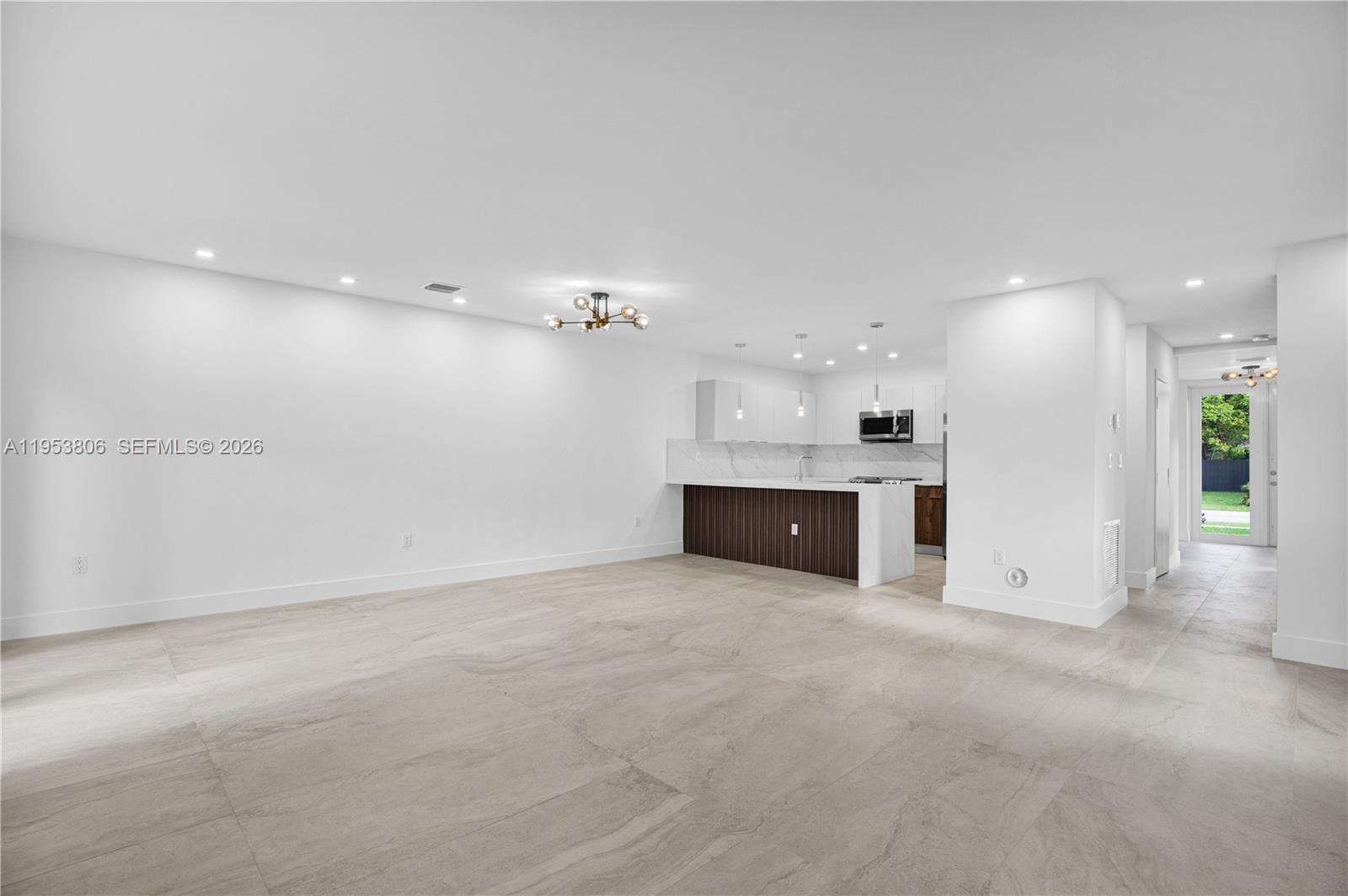 3433 Southwest 16th Terrace Miami, FL 33145 - Photo 6 of 26 an empty room with kitchen view and a fireplace