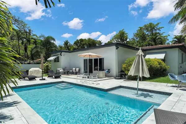 a view of a house with backyard sitting area and garden