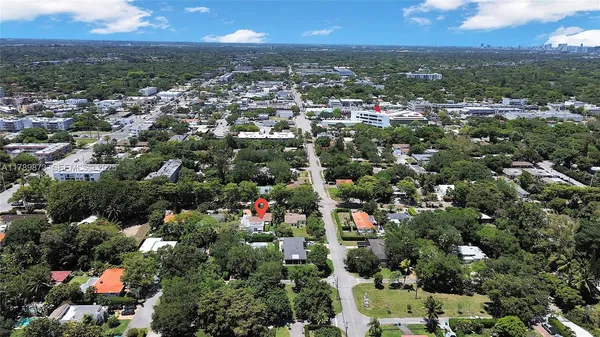 an aerial view of residential houses with outdoor space and trees