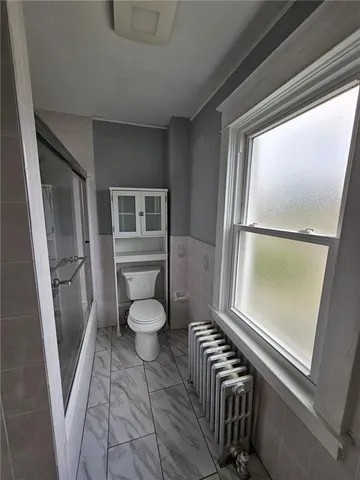 a bathroom with a toilet a sink and a window