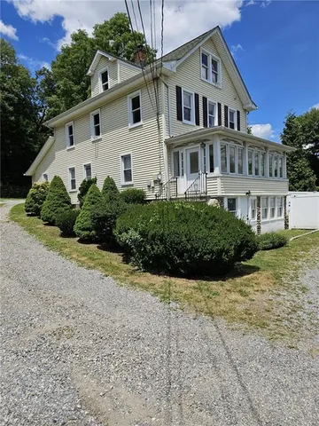 a view of a white house with a yard and plants