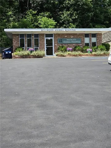 front view of house with a yard and potted plants